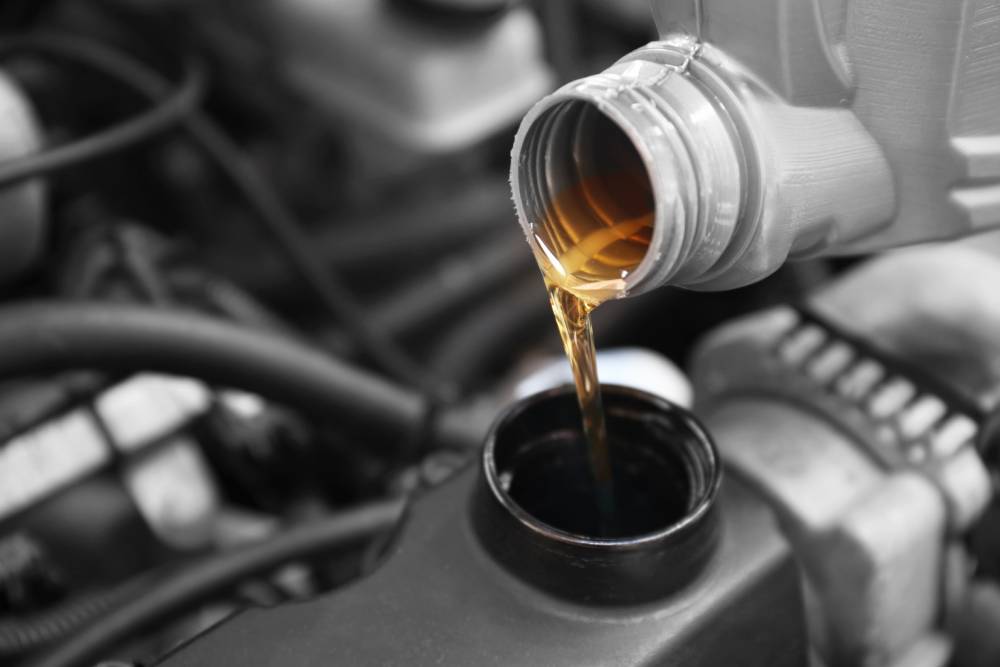 Pouring oil to car engine, close up